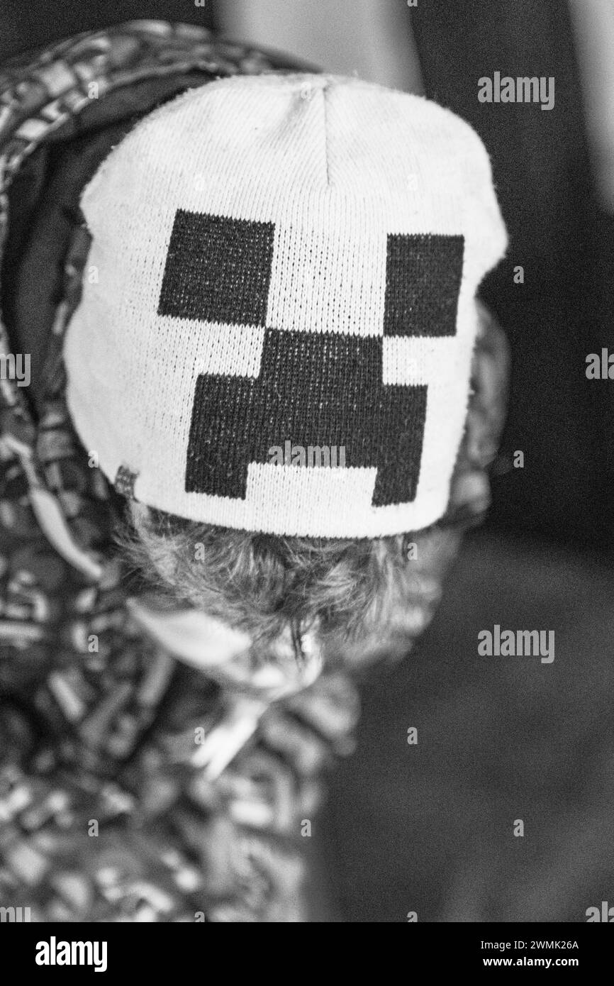 Minecraft Magia. Sombrero de lana de invierno de niño joven. Rostro abstracto, mirada. Diseño pixelado. Foto de stock