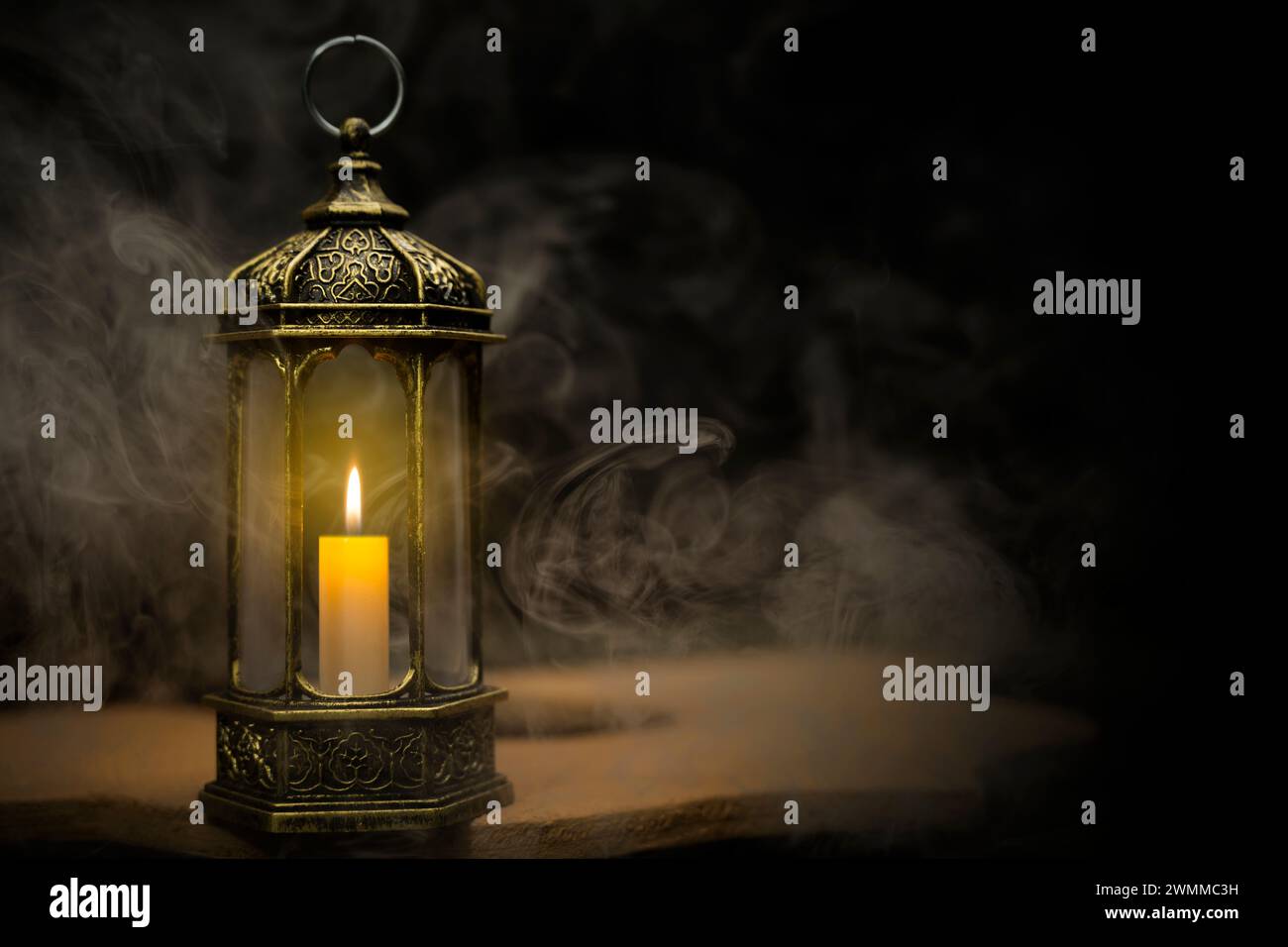 Linterna árabe ornamental con vela ardiente que brilla con un fondo oscuro. Concepto de Ramadán Foto de stock