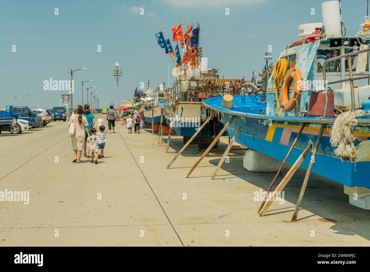 Los turistas que pasean por los arrastreros secos atracaron en el muelle de concreto en Corea del Sur Foto de stock