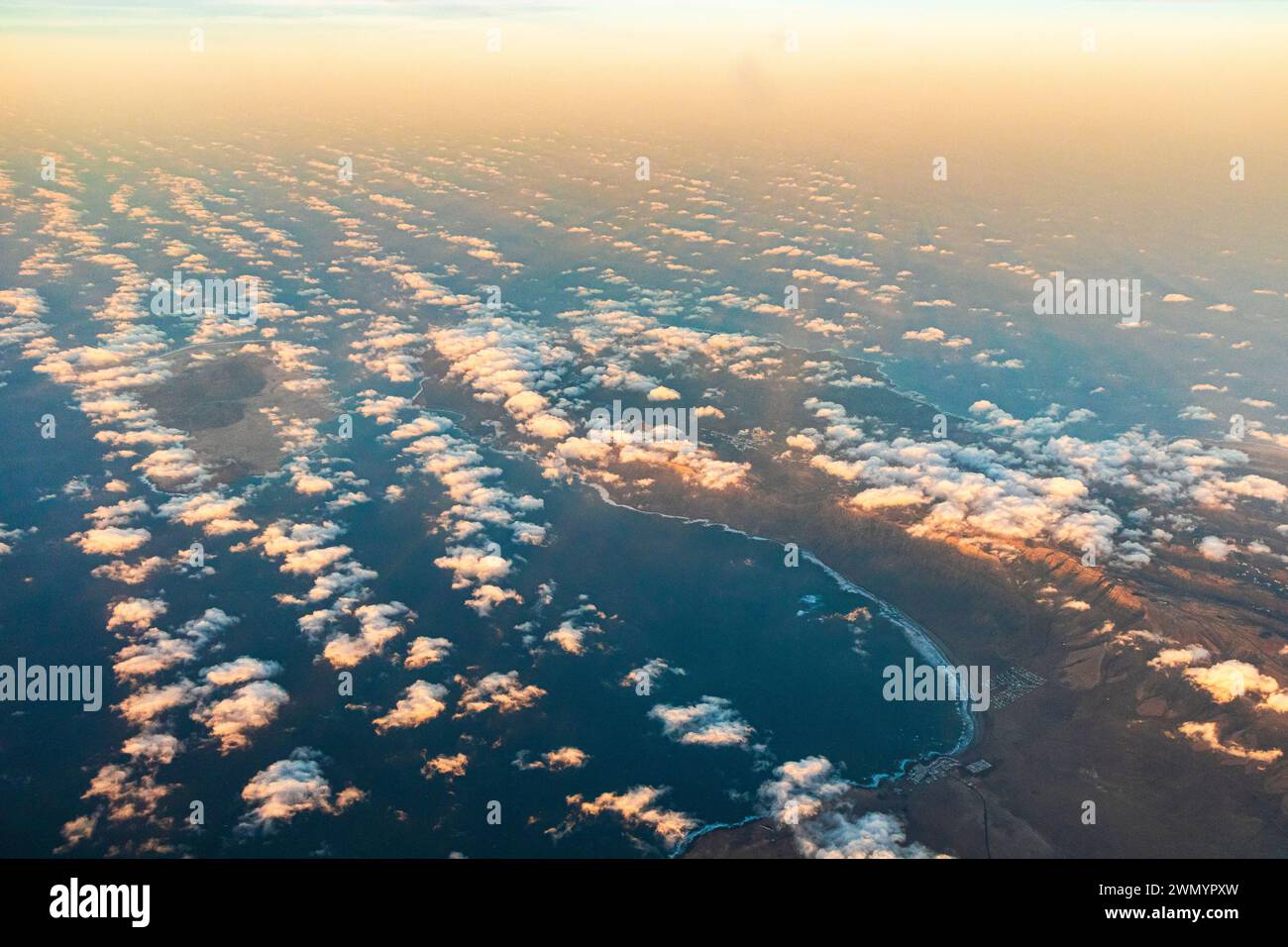 Caleta de Famara y la Bahía de Penedo en la isla canaria de Lanzarote, España visto desde un avión que pasa hacia el atardecer. Foto de stock