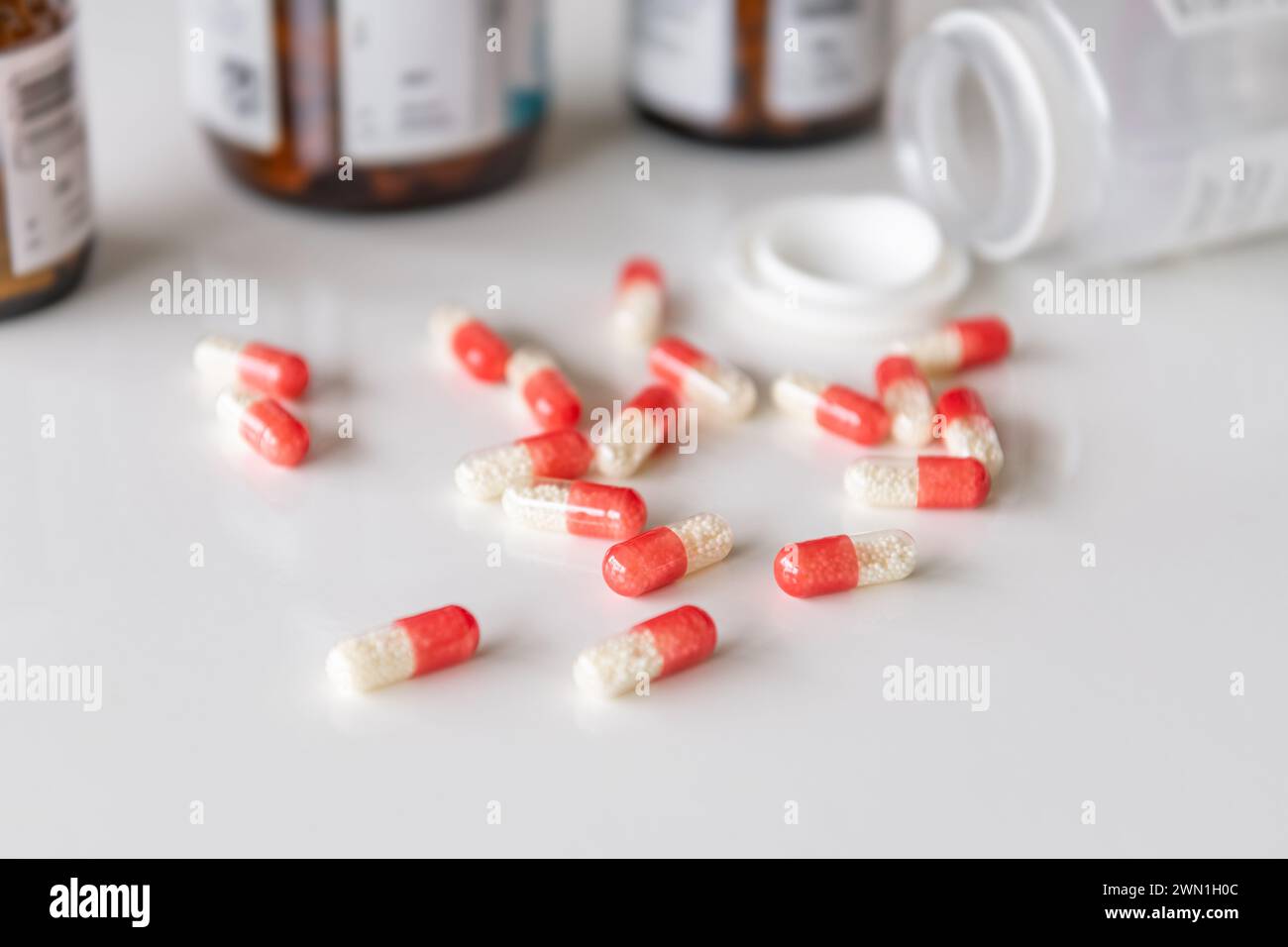 Píldoras medicinales, medicamentos en diferentes colores dispuestos sobre un fondo blanco. Concepto médico de atención de la salud humana. Foto de stock
