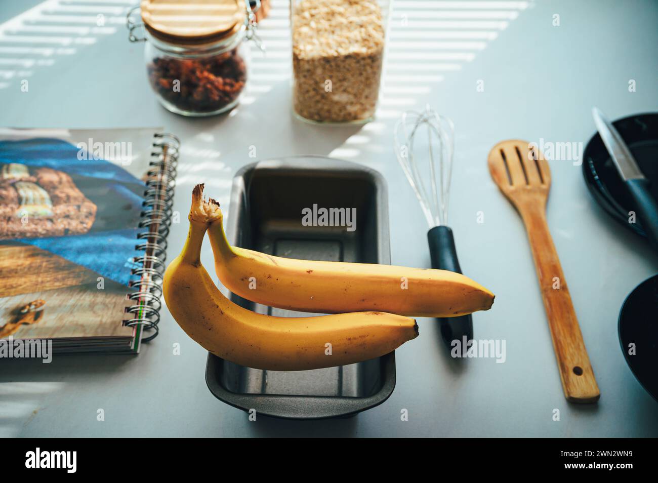 Lo esencial para hornear en un mostrador de cocina: Ingredientes para un pan de plátano perfecto. Foto de stock