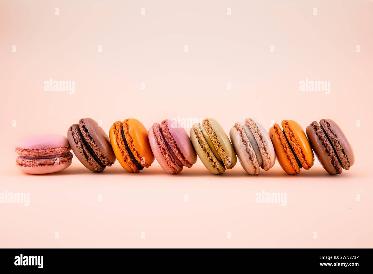 Macarrones franceses multicolores sobre un fondo de color pastel Foto de stock