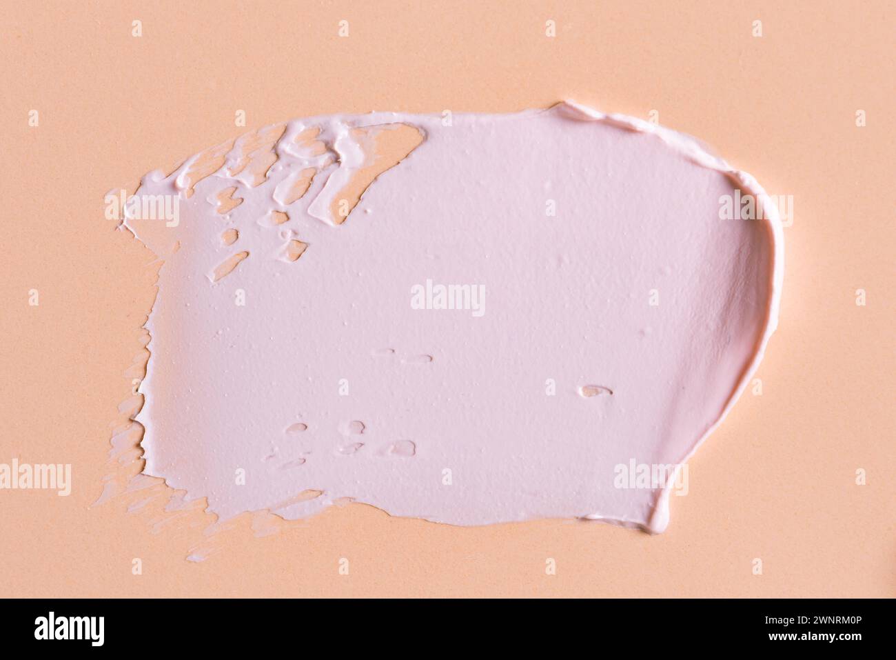 Loción cosmética rosa swatch smear smudge sobre fondo rosa beige. Trazo de rico producto cosmético de arcilla. Foto de stock
