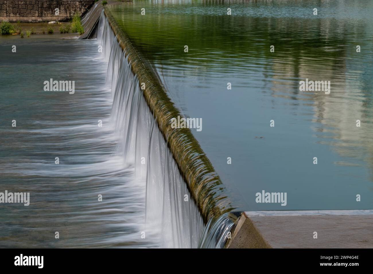 El agua cae en cascadas por un vertedero, creando un efecto de cascada suave, en Corea del Sur Foto de stock