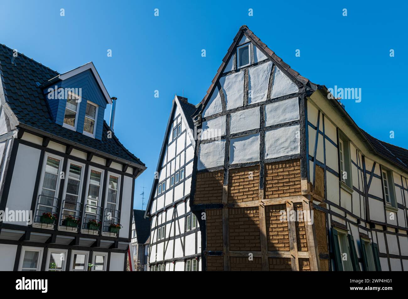 Impresionante casa histórica de entramado de madera con estructuras distintivas contra un cielo azul, casco antiguo, Hattingen, distrito de Ennepe-Ruhr, zona de Ruhr, Norte Foto de stock