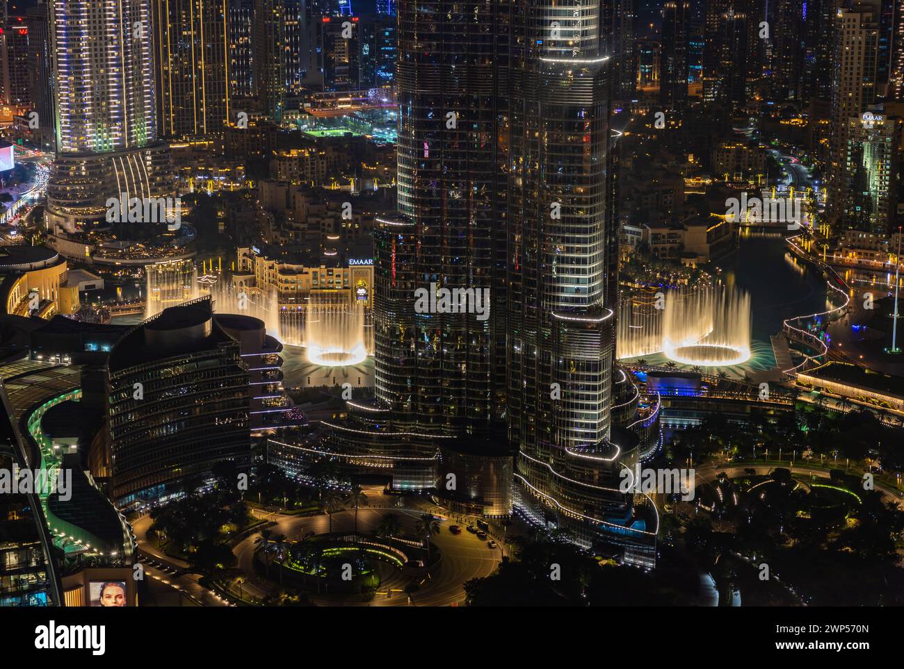 Una foto del Dubai Fountain Show, por la noche, y la parte inferior del Burj Khalifa, junto a otros edificios del centro de Dubai. Foto de stock