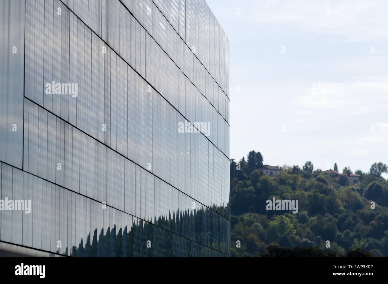 Fachada de edificio moderno, con un innovador sistema de protección solar diseñado en una fachada de vidrio orientada al sur. edificio semicircular, con líneas onduladas de mol Foto de stock