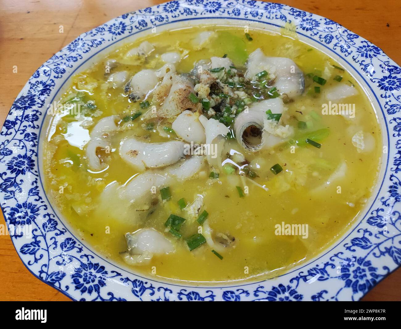 rebanada de pescado con repollo agrio en la sopa amarilla con verduras Foto de stock