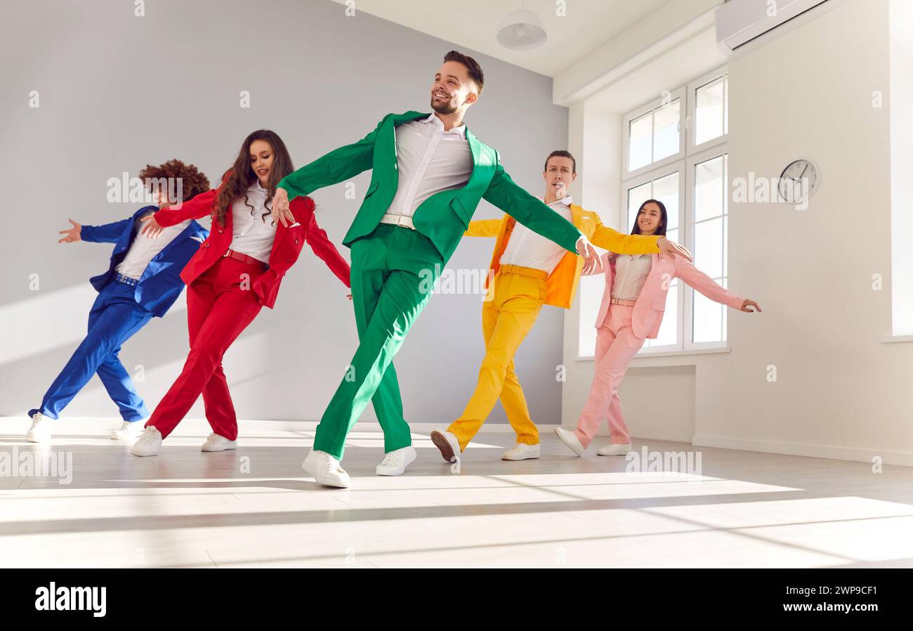 Sonriente grupo de bailarines en trajes coloridos bailando en la fiesta Foto de stock