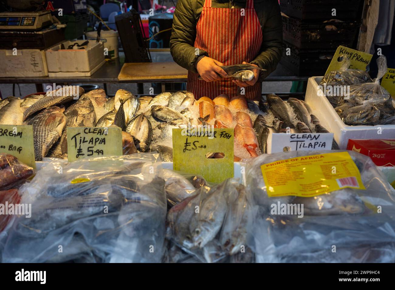 Londres, Reino Unido. 6 de marzo de 2024. Un pescadero en el mercado al aire libre en Dalston, al este de Londres, como Jeremy Hunt, Canciller de Hacienda, da su discurso sobre el presupuesto a los parlamentarios en la Cámara de los Comunes. Crédito: Stephen Chung / Alamy Live News Foto de stock