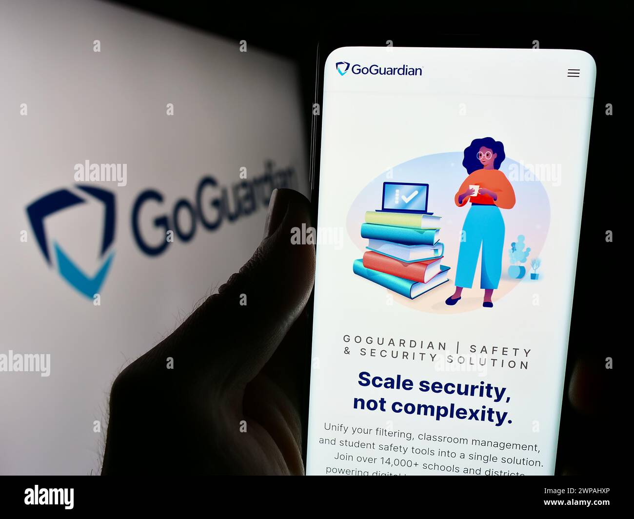 Persona que sostiene el smartphone con el sitio web de la compañía de software educativo estadounidense Liminex Inc. (GoGuardian) con logo. Enfoque en el centro de la pantalla del teléfono. Foto de stock