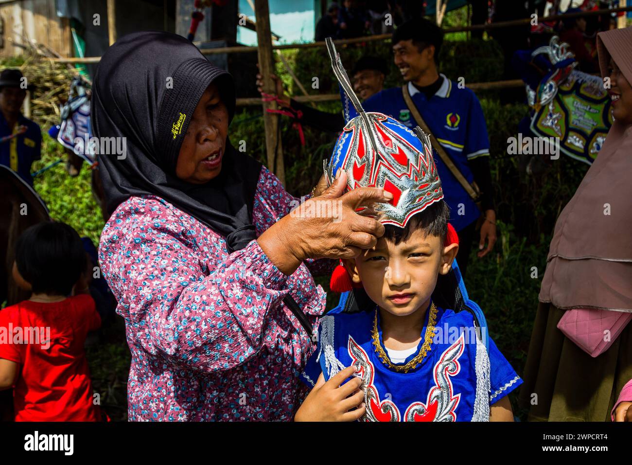 Sumedang, Java Occidental, Indonesia. 7 de marzo de 2024. Una mujer prepara a su hijo antes de perfom en Tanjungsari, regencia de Sumedang. Caballo Danzante, también conocido como ''Kuda Renggong'', es una de las artes escénicas tradicionales y culturales de Sumedang La palabra ''renggong'' proviene del Sundanese ''ronggeng'' o ''kamonesan'' que significa habilidad. El caballo renggong ha sido entrenado en sus habilidades para poder bailar según el acompañamiento de la música tradicional Sundanesa. (Imagen de crédito: © Algi Febri Sugita/ZUMA Press Wire) ¡SOLO USO EDITORIAL! No para USO comercial! Foto de stock