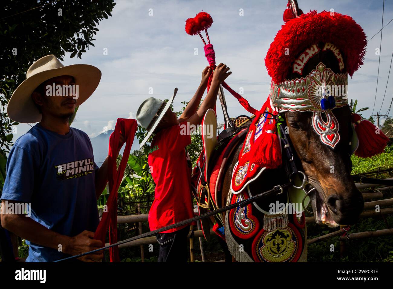 Sumedang, Java Occidental, Indonesia. 7 de marzo de 2024. Los hombres preparan un caballo bailando antes de una actuación en Tanjungsari, Sumedang Regency. Caballo Danzante, también conocido como ''Kuda Renggong'', es una de las artes escénicas tradicionales y culturales de Sumedang La palabra ''renggong'' proviene del Sundanese ''ronggeng'' o ''kamonesan'' que significa habilidad. El caballo renggong ha sido entrenado en sus habilidades para poder bailar según el acompañamiento de la música tradicional Sundanesa. (Imagen de crédito: © Algi Febri Sugita/ZUMA Press Wire) ¡SOLO USO EDITORIAL! No para USO comercial! Foto de stock