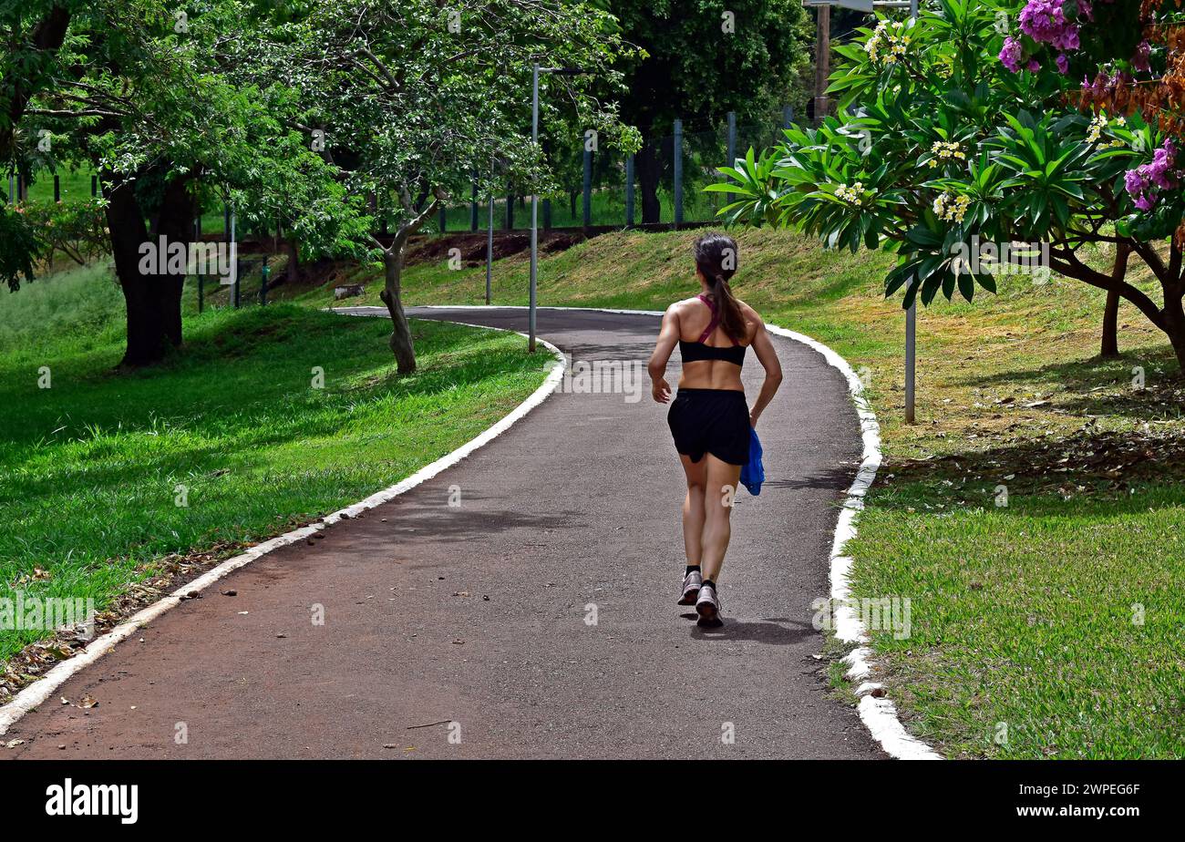 RIBEIRAO PRETO, SAO PAULO, BRASIL - 24 de diciembre de 2023: Mujer adulta corriendo en el parque público Foto de stock