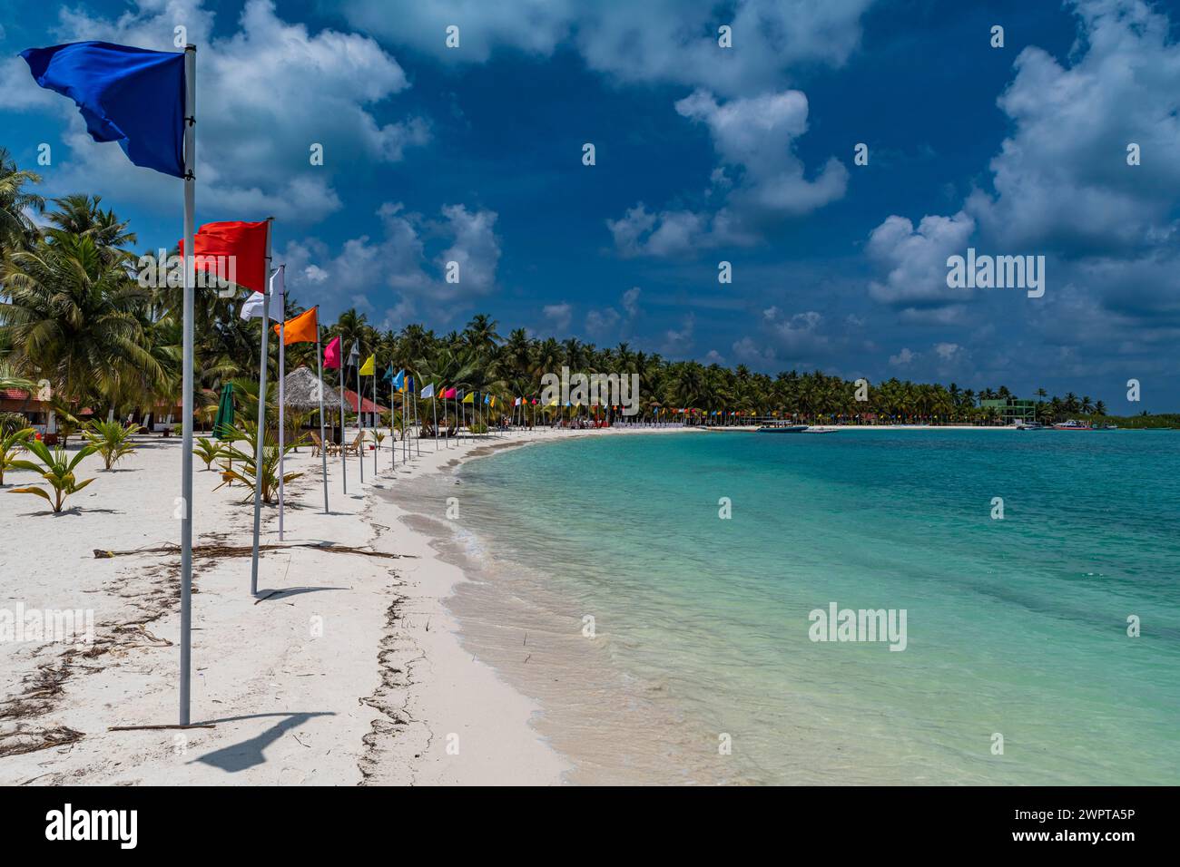 Playa de arena blanca con muchas banderas, isla de Bangaram ...