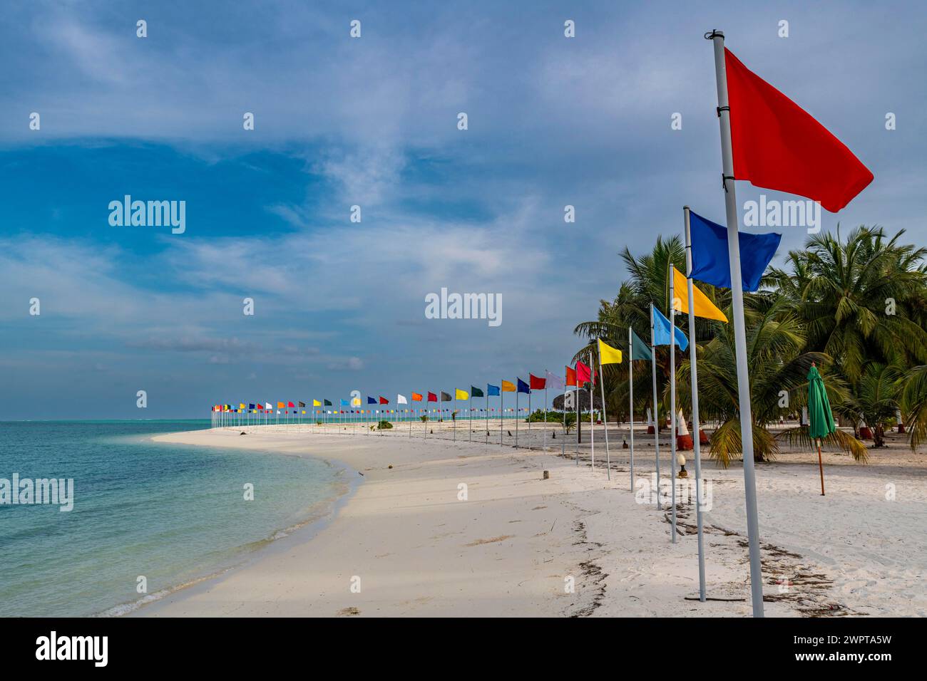 Playa de arena blanca con muchas banderas, isla de Bangaram ...