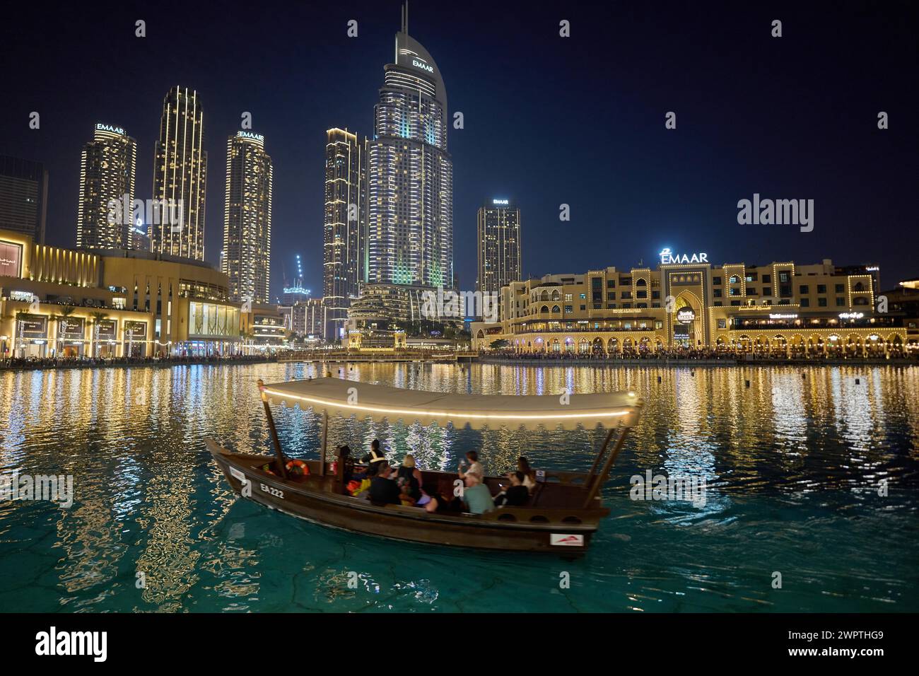 Dubái, Emiratos Árabes Unidos, AsiaTuristas viajan en un barco frente al telón de fondo del rascacielos en el lago Burj Khalifa Foto de stock