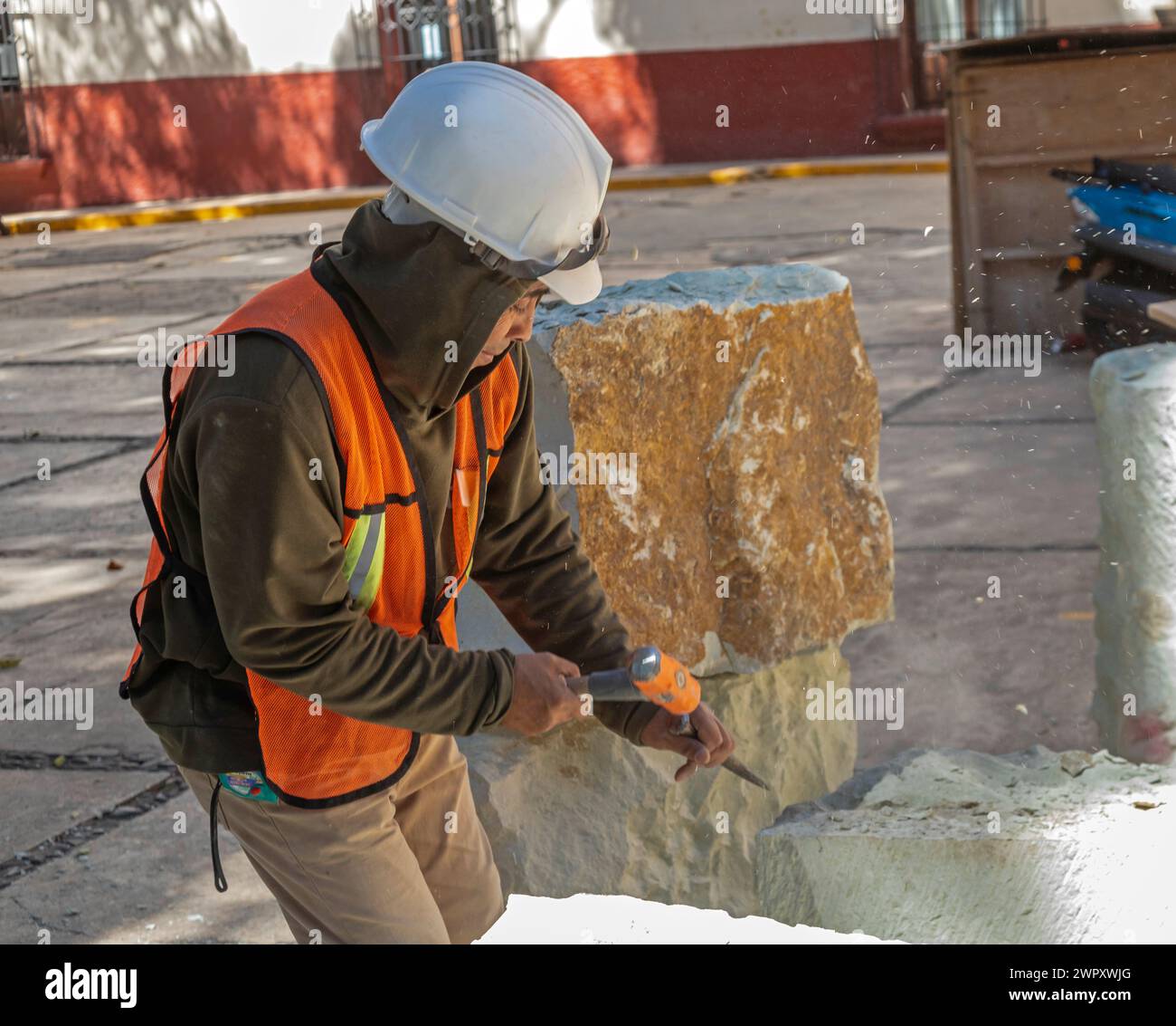 Oaxaca, México - Un trabajador cincela un bloque de piedra para usar en reparaciones en la Iglesia de Guadalupe. Foto de stock