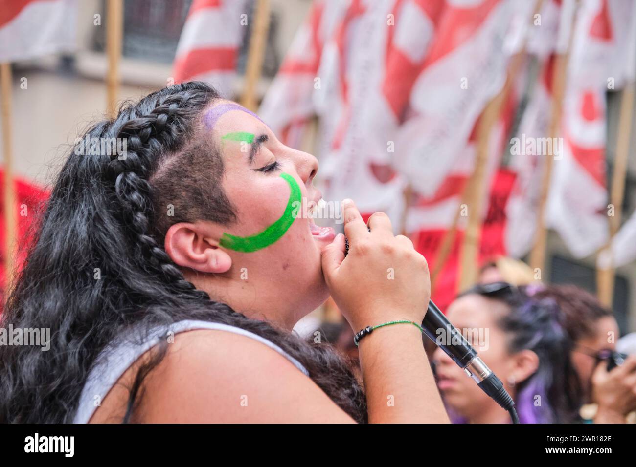 Buenos Aires, Argentina; 8 de marzo de 2024: Poderoso retrato editorial de una joven que canta consignas feministas con los ojos cerrados mientras marchaba sin rumbo Foto de stock