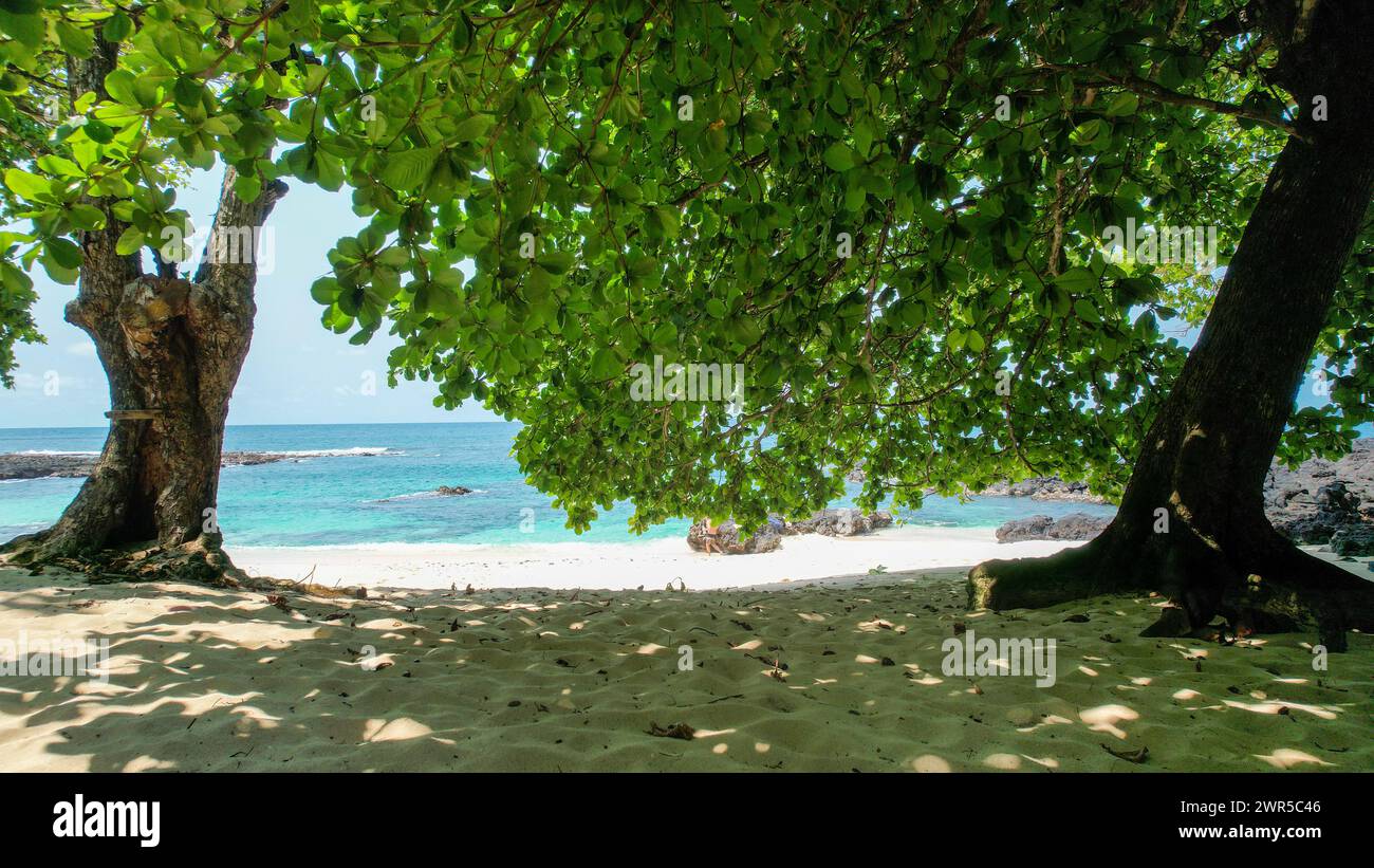 Una playa tropical con Ilheu das Rolas en Santo Tomé, África Foto de stock