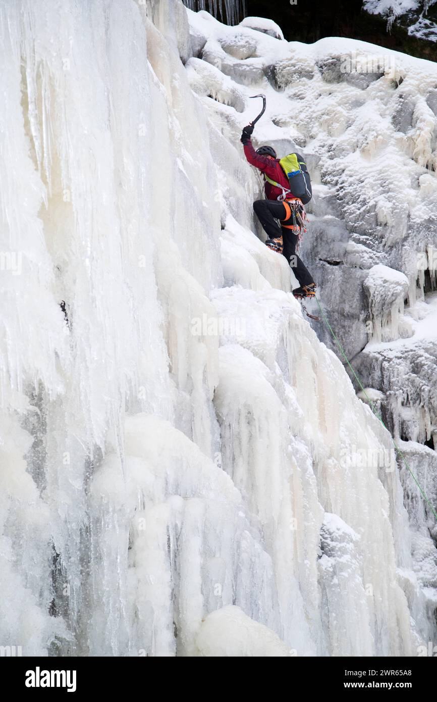 03/01/19 Después de una de las noches más frías del año, un escalador de hielo se abre camino por la cara congelada de la caída de Kinder, que normalmente es de 30 metros Foto de stock