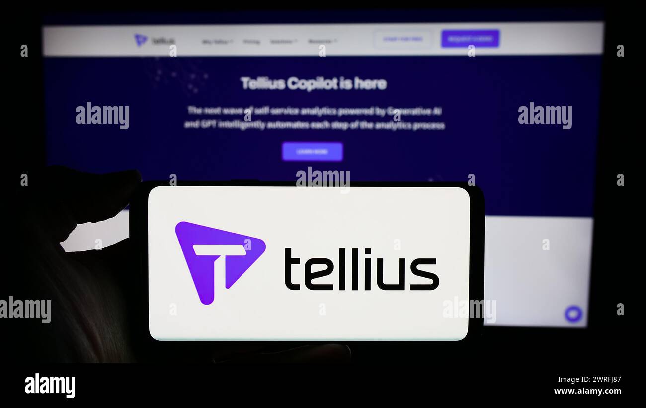 Persona que sostiene el teléfono celular con el logotipo de la empresa estadounidense de análisis de inteligencia artificial Tellius Inc. Frente a la página web. Enfoque en la pantalla del teléfono. Foto de stock