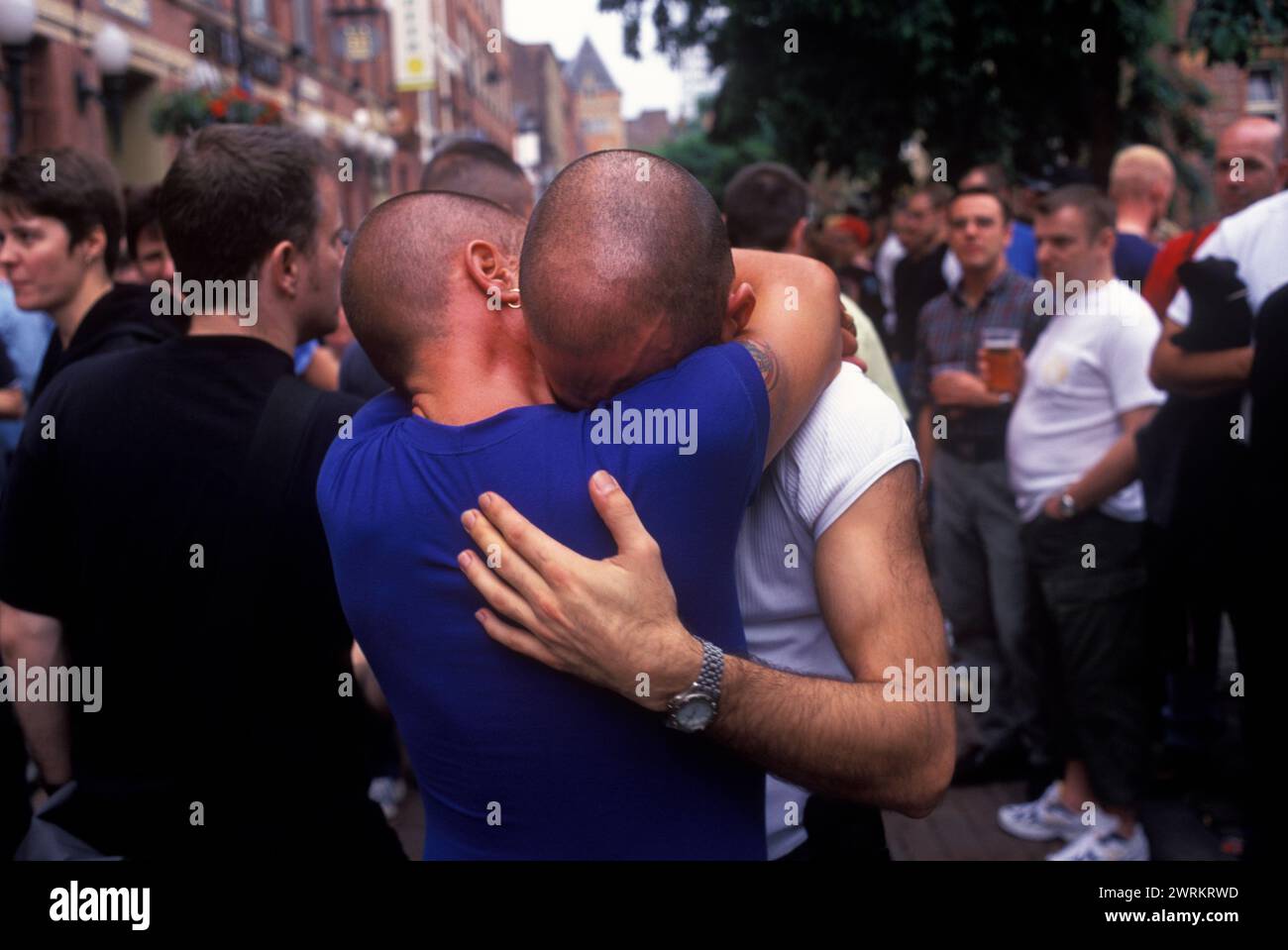 Los hombres homosexuales comparten su dolor en los 1990 del Reino Unido. El festival anual del Orgullo Gay se celebra en Canal Street durante el desfile anual del Gayfest, los hombres se abrazan y se sostienen, recordando a amigos que han muerto recientemente de SIDA. Festival del Orgullo de Manchester, Lancashire Inglaterra 1999. HOMER SYKES Foto de stock