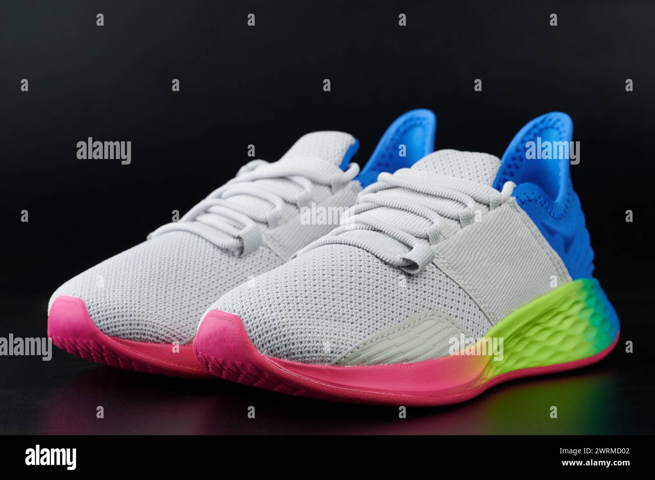 Tema del calzado deportivo. Zapatos de running grises con suela colorida arco iris Foto de stock