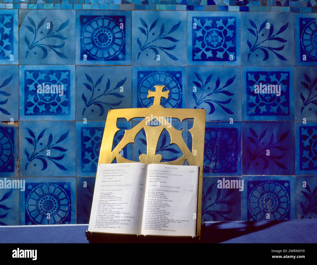 Azulejos de vidrio azul de inspiración islámica y victoriana, y un soporte de libros de latón, en el Santuario de la Iglesia de San Patricio, Llanbadrig, Anglesey, Gales, Reino Unido. Foto de stock