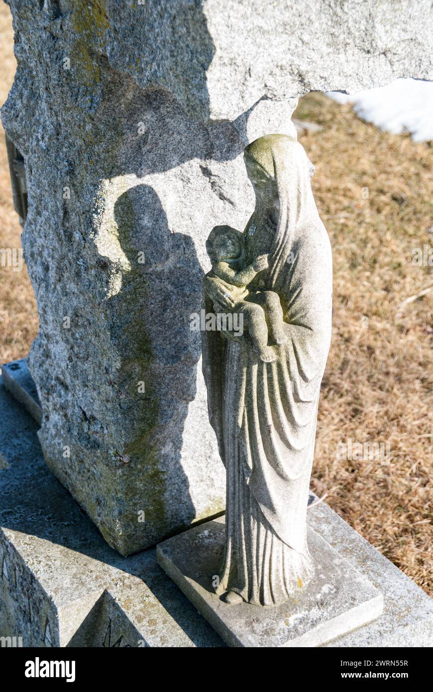 Una tumba marcada con una elaborada pequeña estatura de la Virgen María sosteniendo a un niño Foto de stock