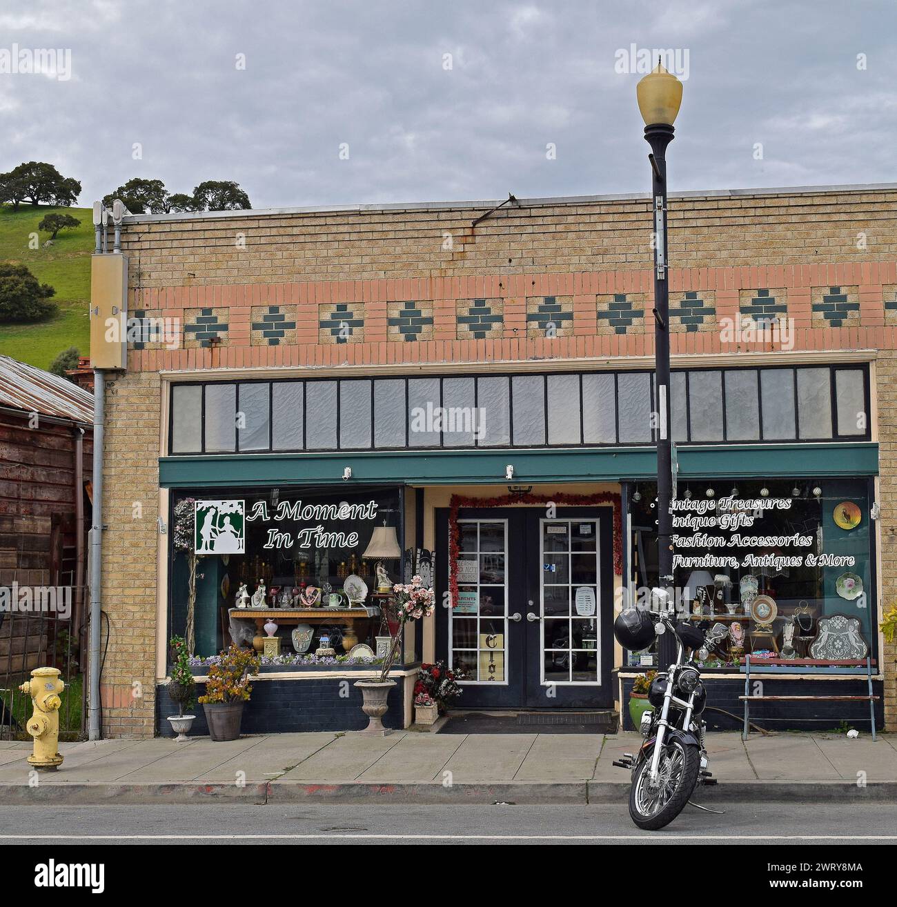 Motocicleta estacionada en Niles Blvd, Una tienda de antigüedades Moment in Time en el distrito de Niles de Fremont, California, Foto de stock