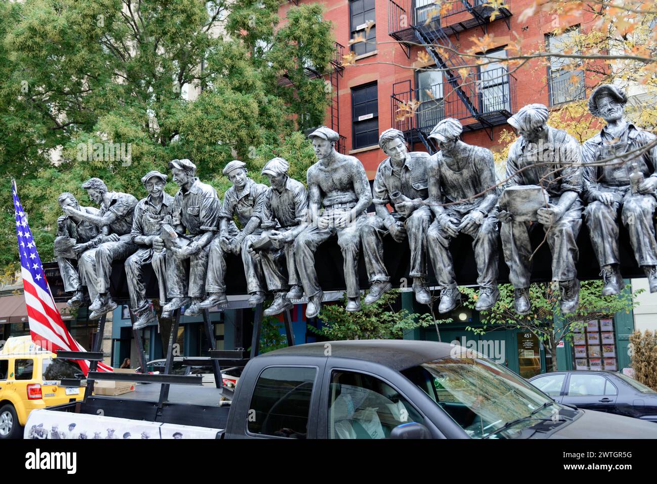 Esculturas de tamaño natural de trabajadores con una bandera americana en el fondo, Manhattan, Nueva York, Nueva York, EE.UU., América del Norte Foto de stock