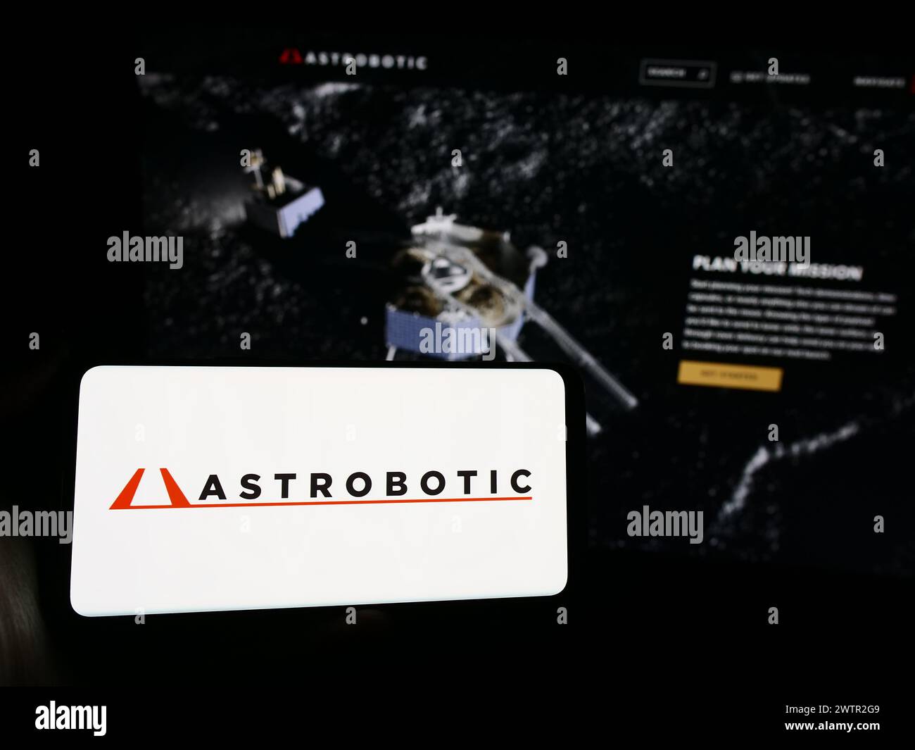 Persona que sostiene el smartphone con el logotipo de la compañía estadounidense de robótica espacial Astrobotic Technology Inc. Frente al sitio web. Enfoque en la pantalla del teléfono. Foto de stock