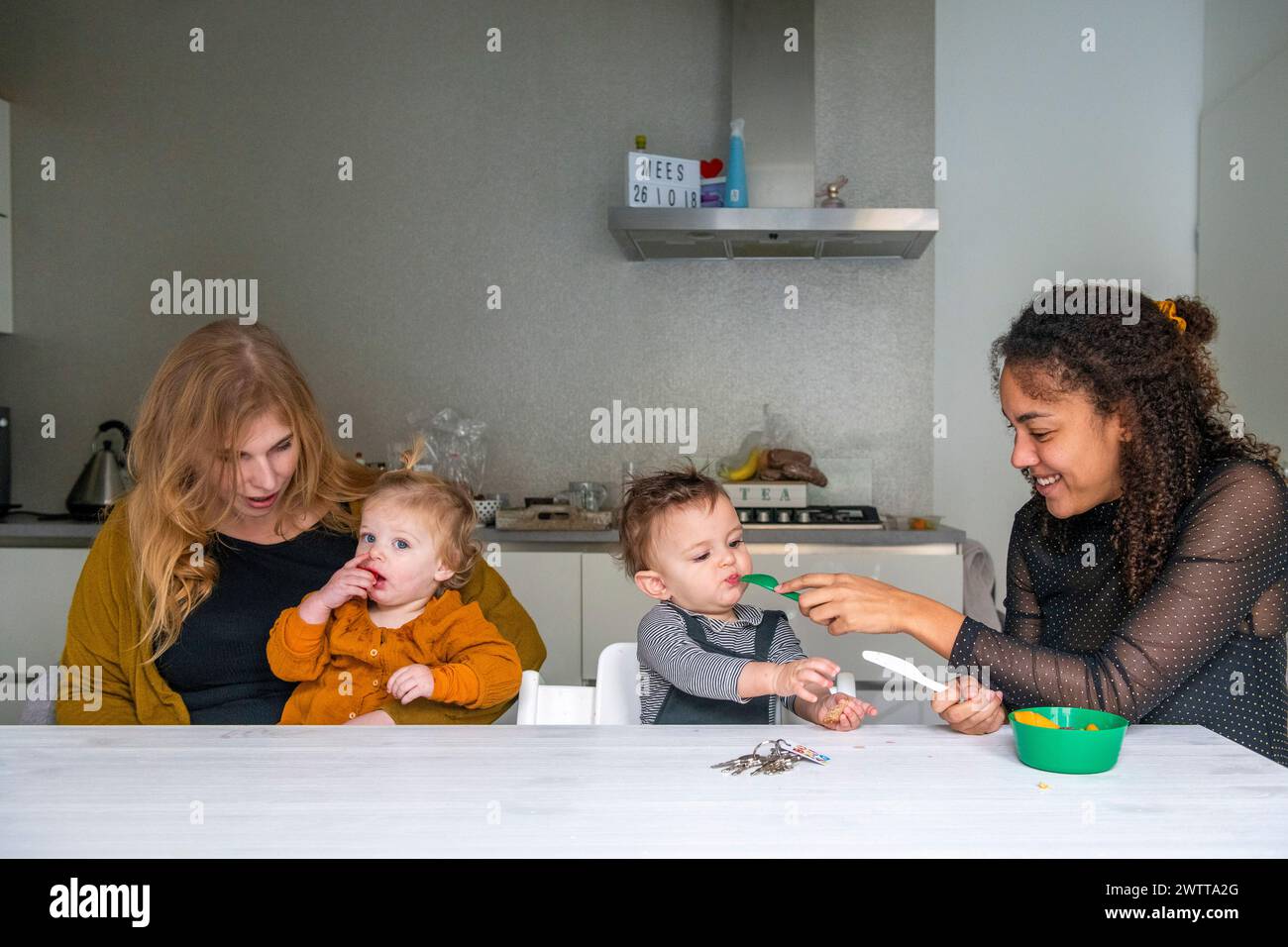 Diversión familiar mientras mamá y niños disfrutan de las artes y manualidades en casa. Foto de stock