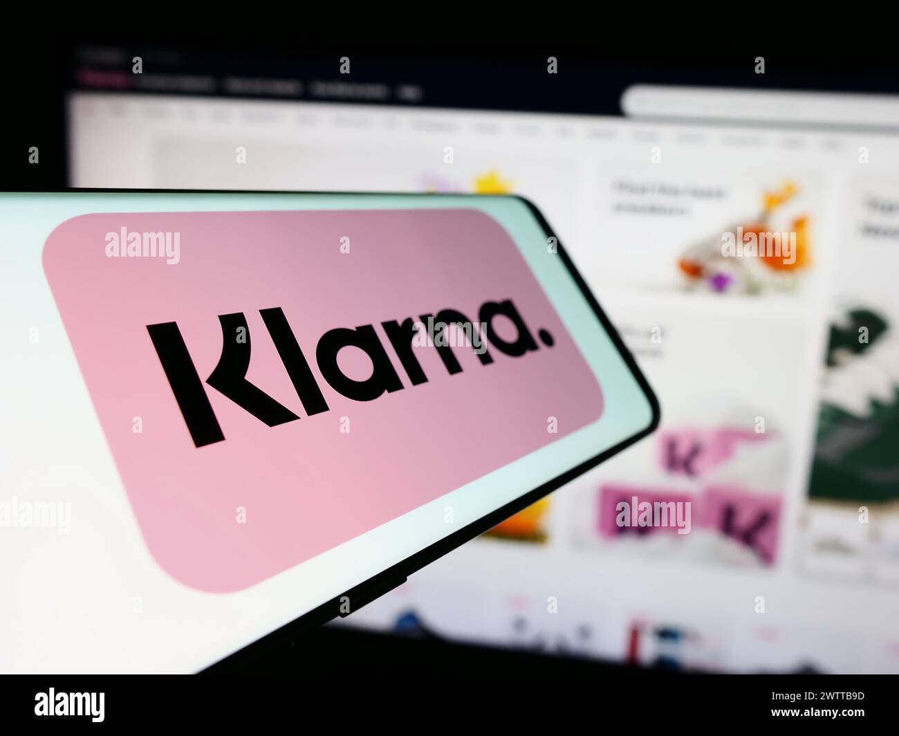 Teléfono móvil con el logotipo de la empresa fintech sueca Klarna Bank AB frente al sitio web del negocio. Enfoque en centro-izquierda de la pantalla del teléfono. Foto de stock