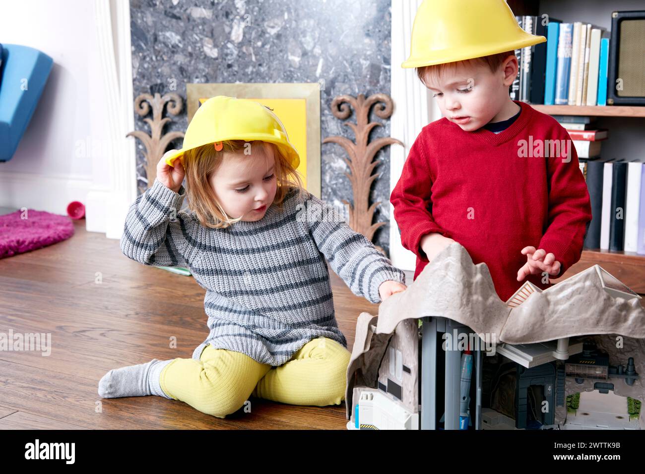 Dos niños jugando con juguetes de construcción Foto de stock