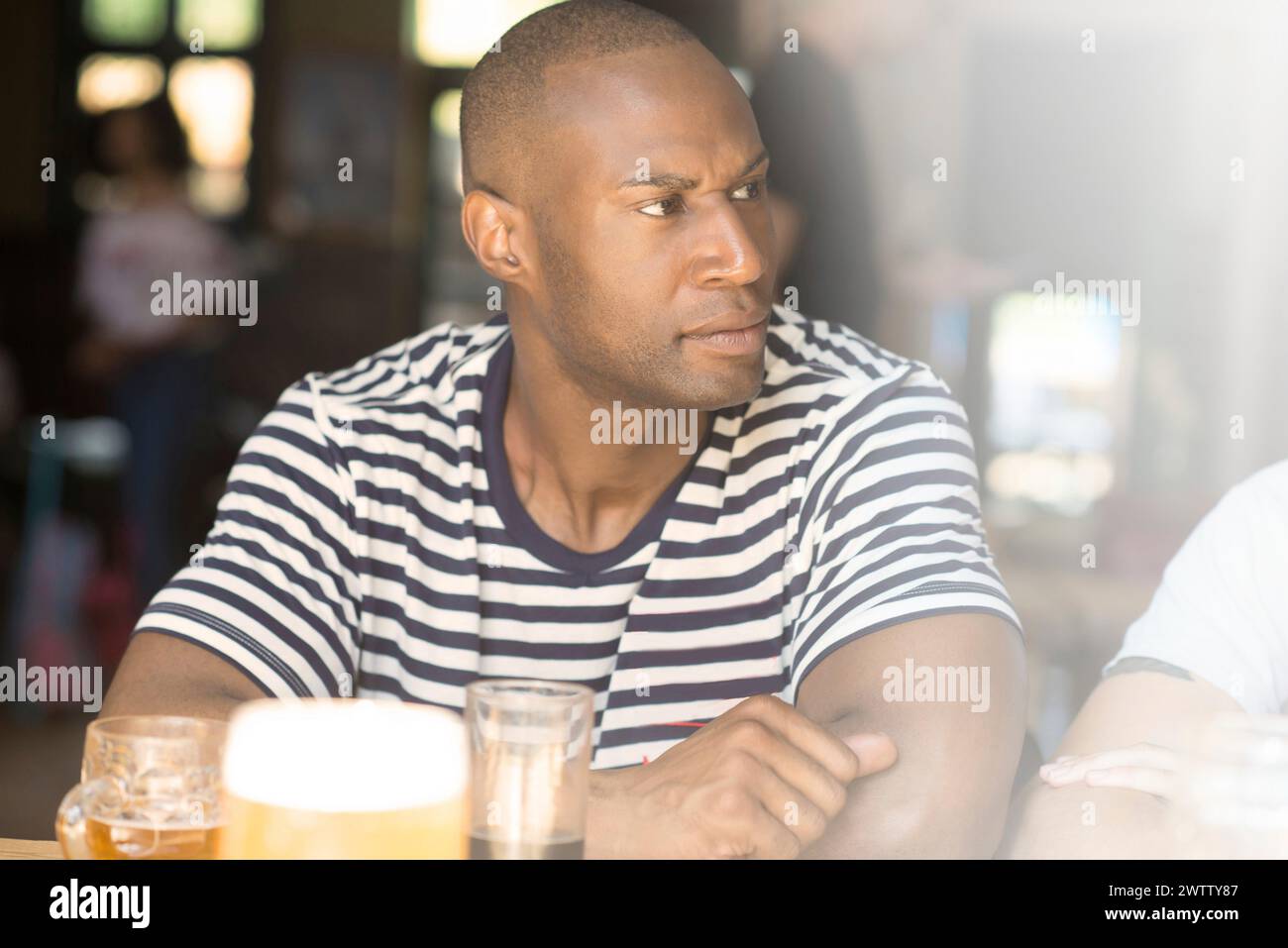 Hombre en camisa de rayas en un bar Foto de stock