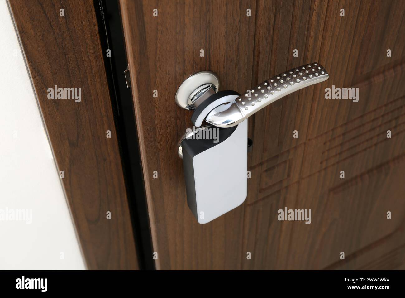 Puerta de madera oscura con percha de puerta en la habitación del hotel Foto de stock