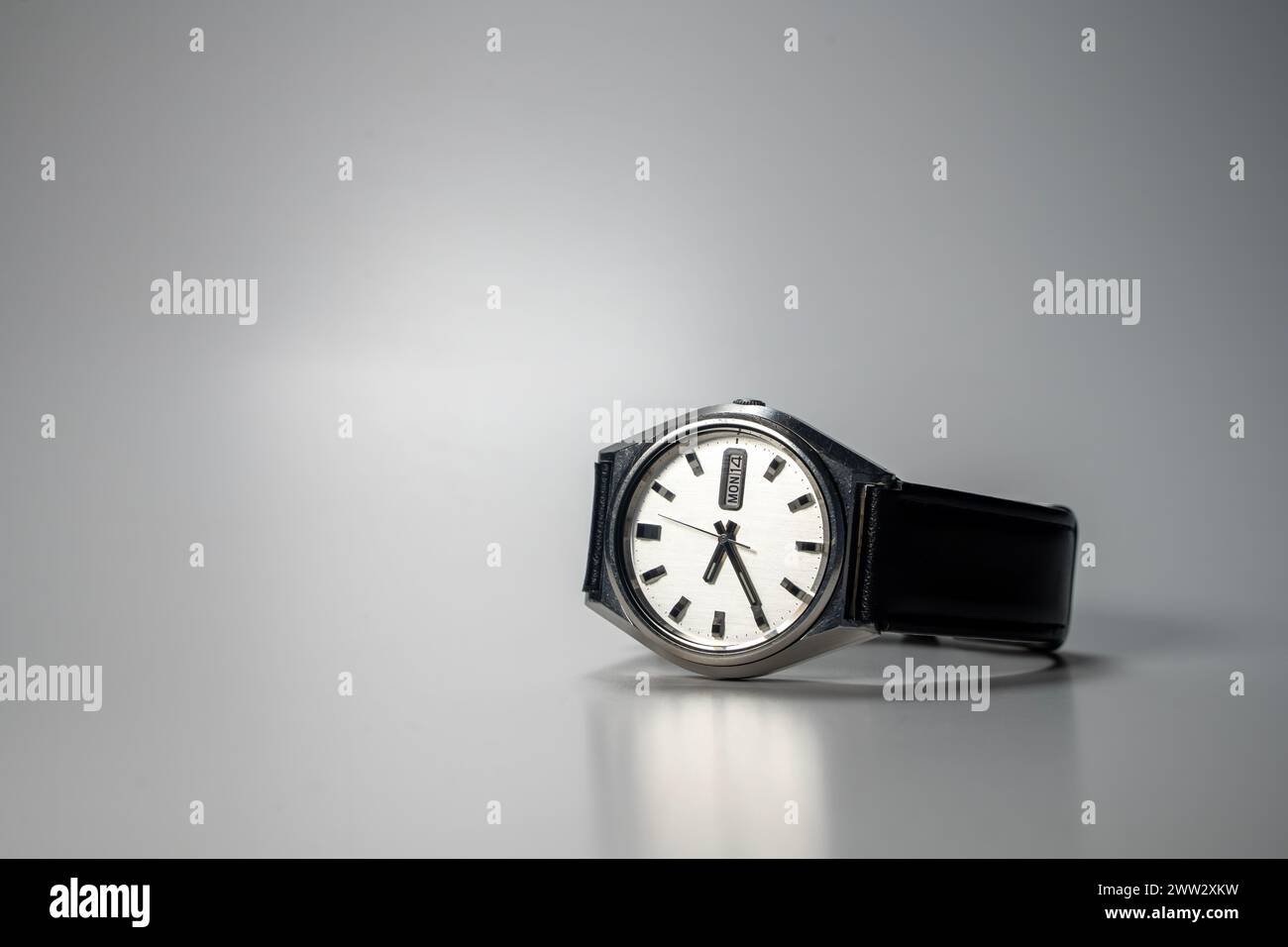 Vintage reloj de pulsera automático con correa de cuero, colocado en la superficie gris Foto de stock