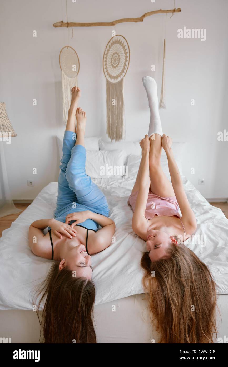 Dos jóvenes amigas hermosas en la cama disfrutando del tiempo libre juntos  Fotografía de stock - Alamy