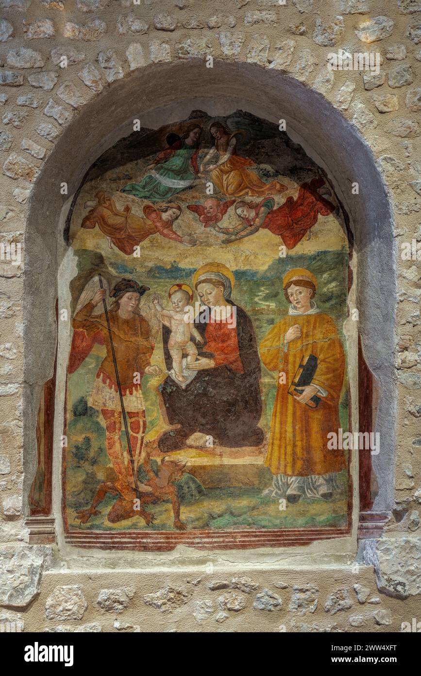 En un nicho de la Basílica de Santa María de Collemaggio, un fresco que representa a una Virgen con el Niño y los Santos. L'Aquila, Abruzos, Italia, Europa Foto de stock