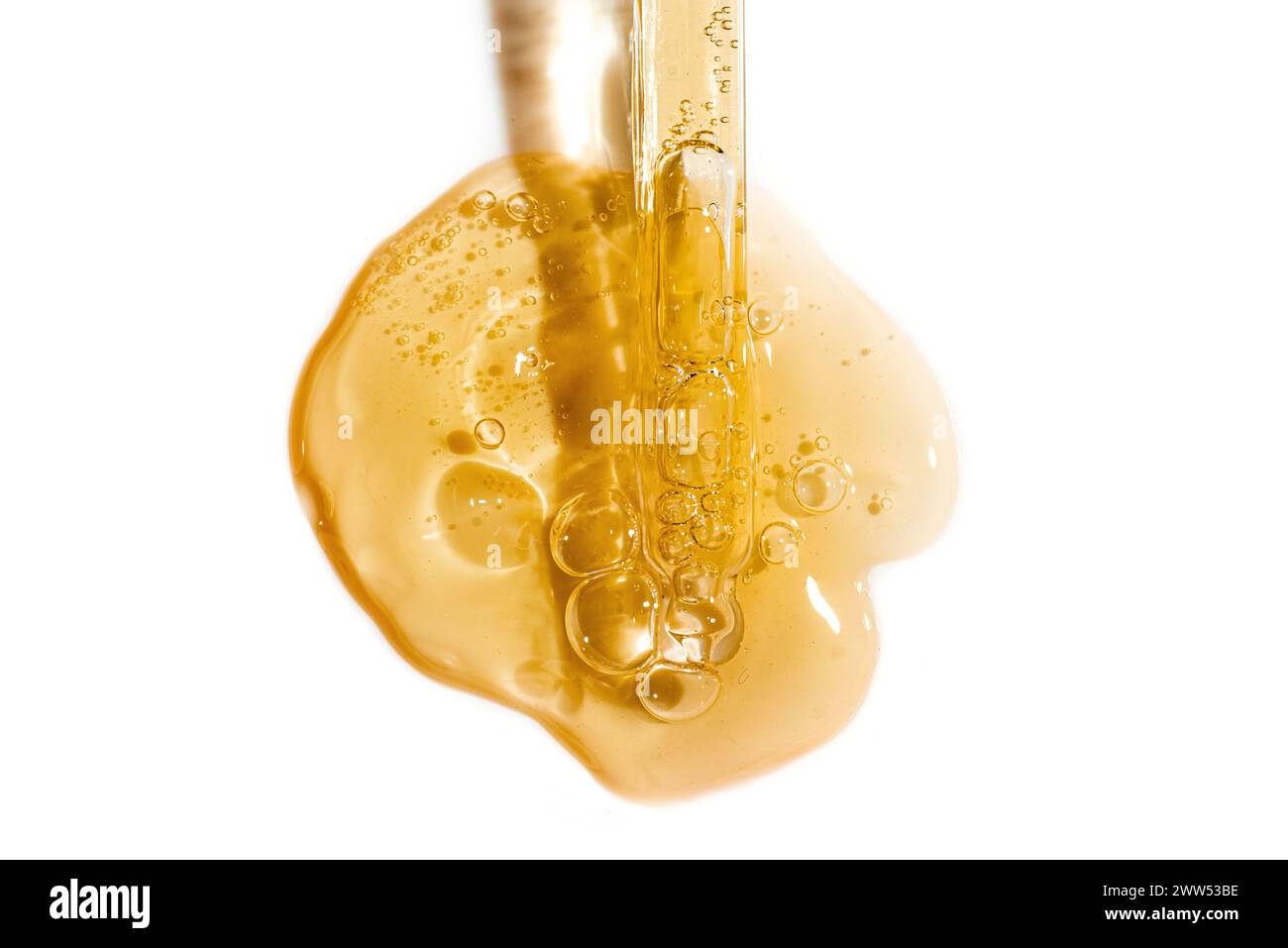 Pipeta de gotero y muestra de suero de cara dorada o gel de retinol aislado sobre fondo blanco. Cuidado de la piel con aceite o péptido. Textura swatch de cosmética Foto de stock