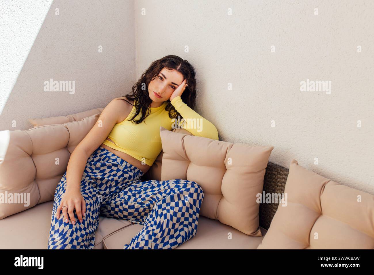 Mujer joven sentado en un sofá en casa Foto de stock