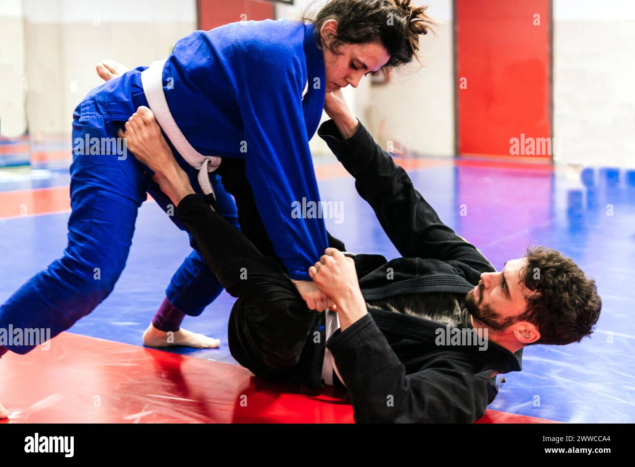 Deportistas que duelen en jujitsu entrenando en dojo Foto de stock