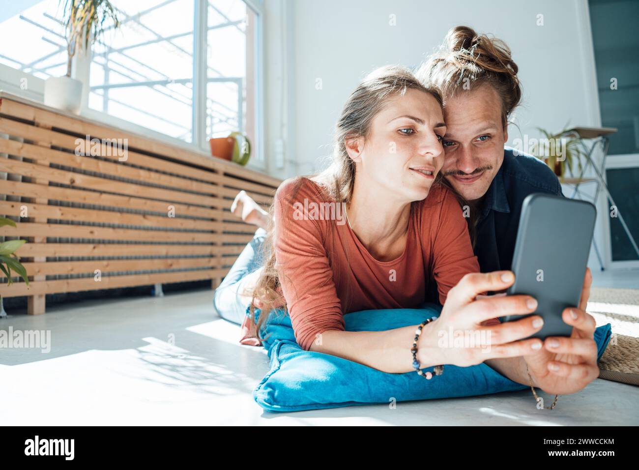 Feliz pareja tomando selfie a través del teléfono inteligente en casa Foto de stock