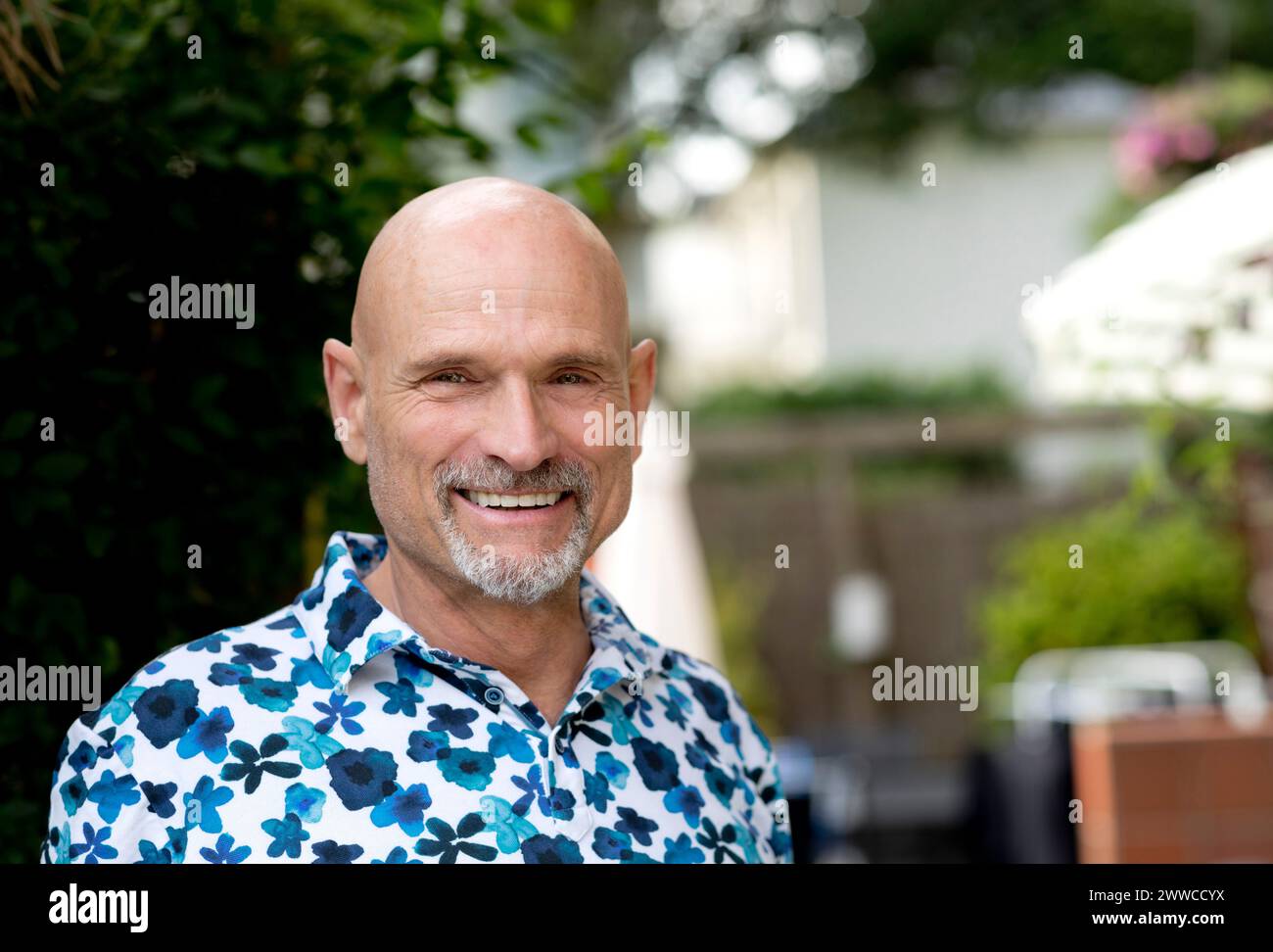 Hombre feliz con cabeza calva en jardín Foto de stock