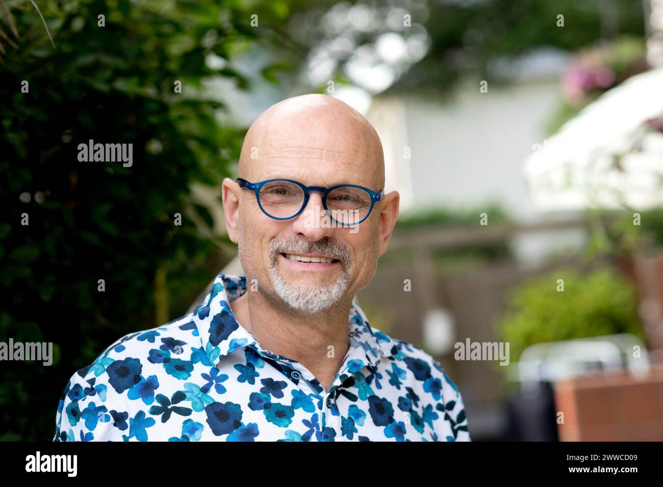 Hombre sonriente usando anteojos en el jardín Foto de stock