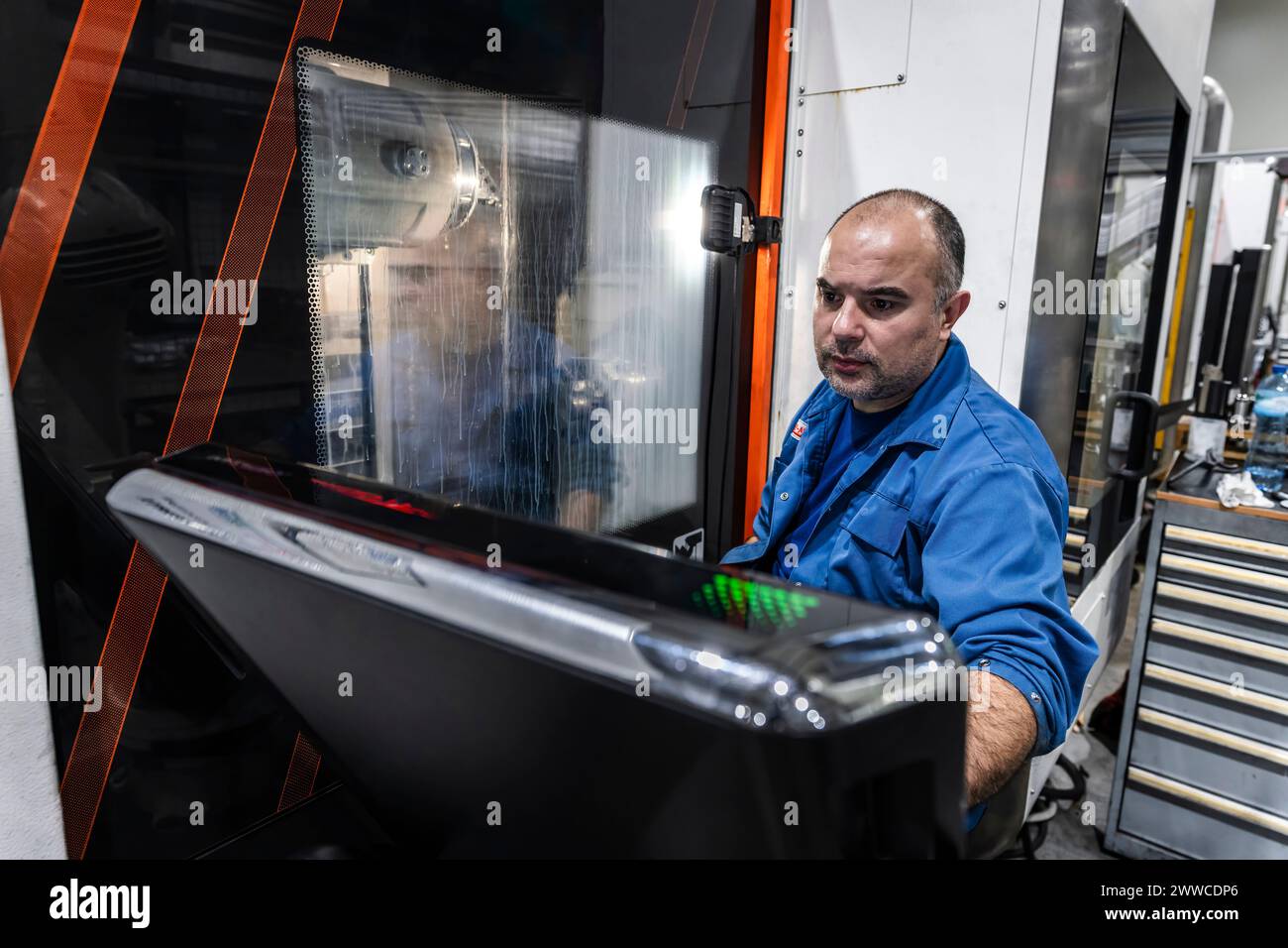 Ingeniero de mantenimiento que opera maquinaria CNC robótica en la fábrica de fabricación Foto de stock