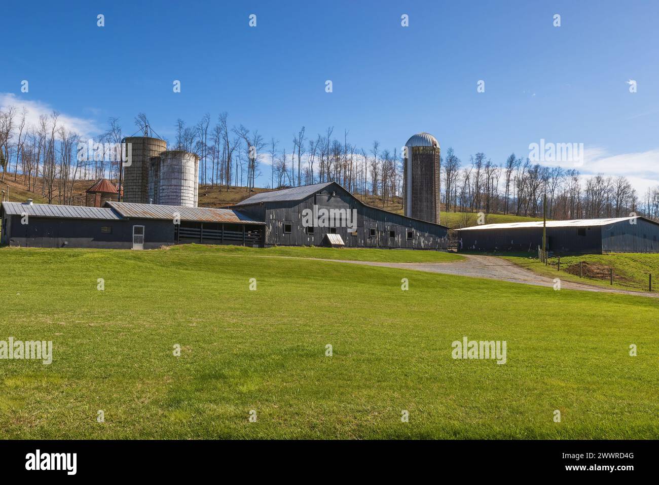 Tierra agrícola donde graneros y silos se sientan en una ladera en el campo rural de Virginia. Foto de stock